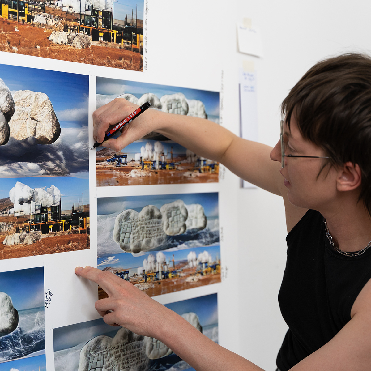 A woman making notes on images on a wall